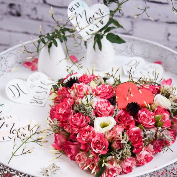 Muttertag Der Blütenwald rosa geschmücktes Herz auf Weißem Tisch Closeup